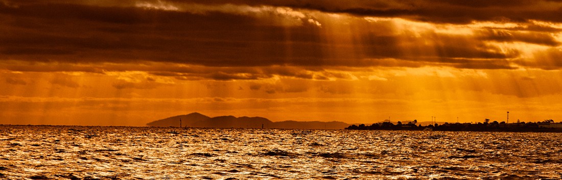 Stormy sky, with rays of sunlight breaking through and ocean